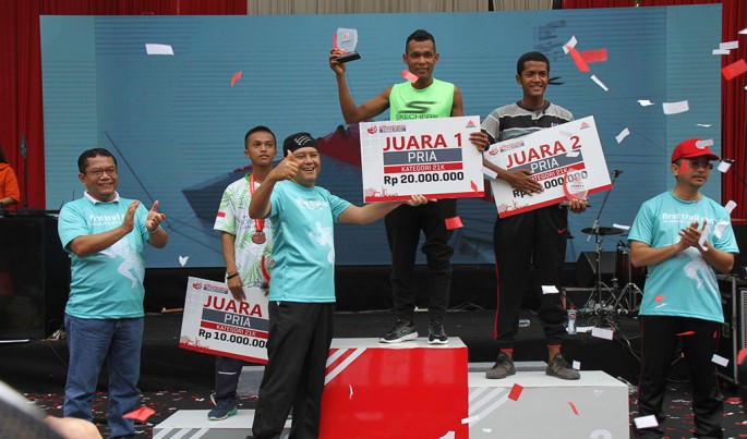 Sekretaris Perusahaan Semen Indonesia, Agung Wiharto menyerahkan hadiah kepada Juara Pertama kategori 21 Kilometer, Hamdan Suyuti dengan catatan waktu 1 Jam 42 Menit 14 Detik.Foto/SemenIndonesia/ECONOMICZONE