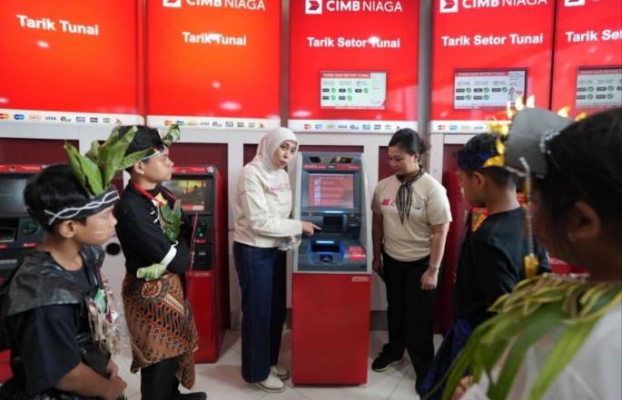 Head of Region Jakarta CIMB Niaga Adeline Hendarto (kanan) bersama Community Development Head Astrid Candrasari , memperkenalkan fungsi mesin ATM kepada para peserta kegiatan Tour de Bank di Kantor Cabang CIMB Niaga Bintaro, Tangsel., Sabtu (13/6/20