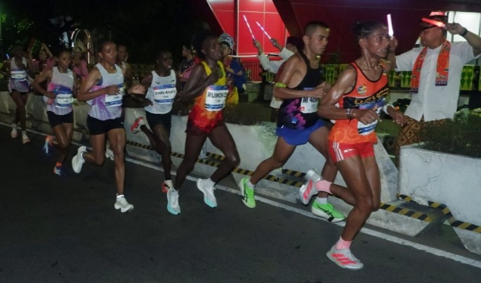 Paguyuban betawi memberikan semangat peserta asal Kenya, di ruas jalan protokol saat mengikuti BTN Jakarta International Marathon (Jakim) 2026, Minggu (14/6). (Foto/Endang Muchtar/ECONOMIC ZONE) 